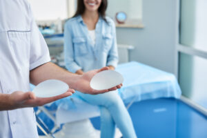 Doctor helping a happy woman choose the right size and shape for her breast implants